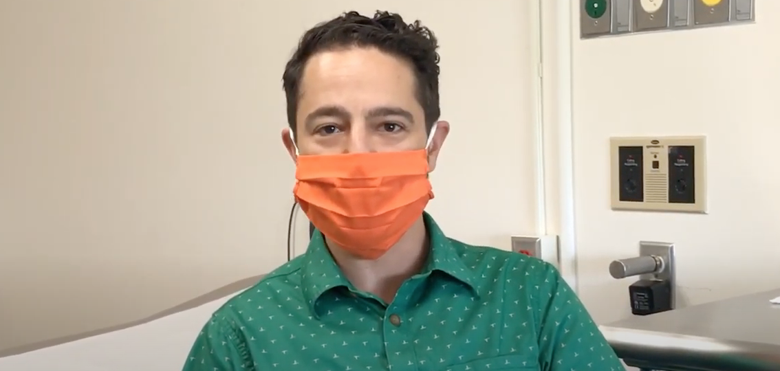 Dr. Zach Borus wearing a orange face mask