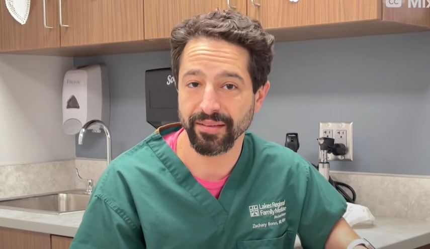 Dr. Zach Borus wearing green scrubs looking at camera