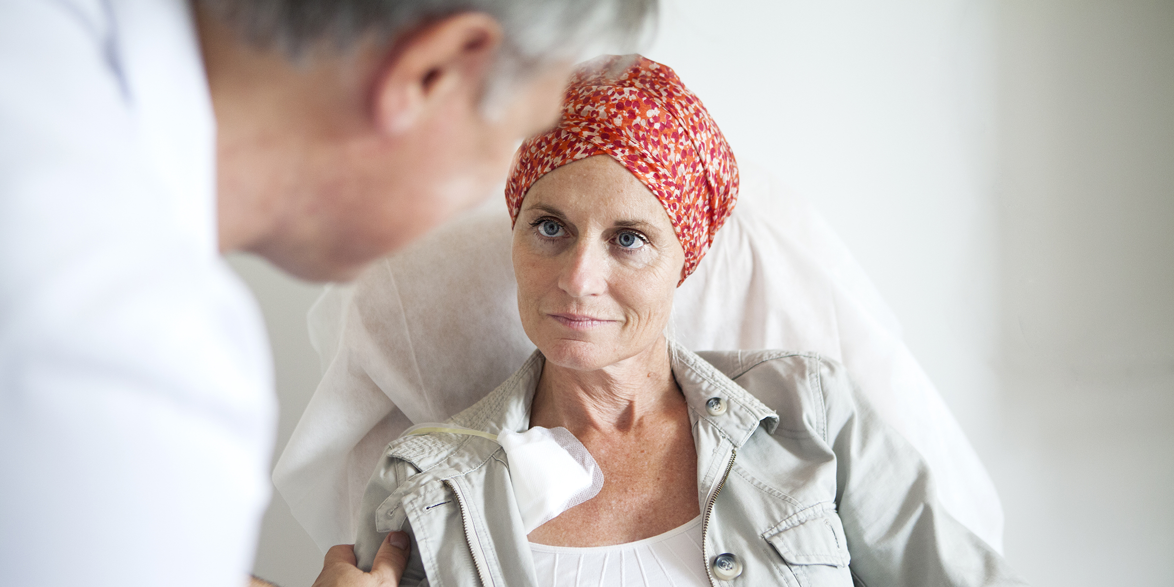 Woman with red scarf on her head talking to a doctor